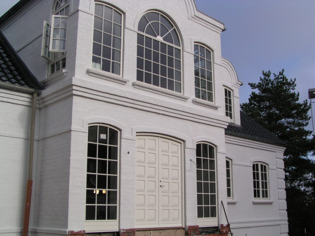 Hvid facade med dobbelt hoveddør og koblede vinduer